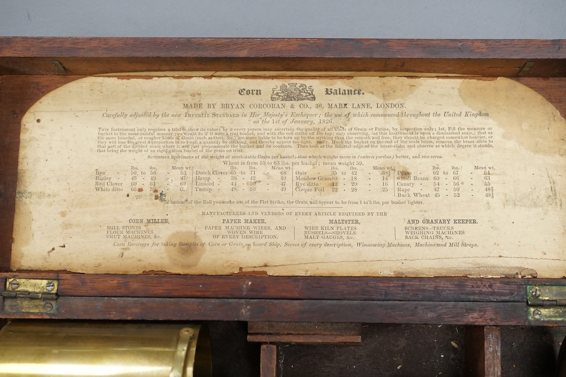 A 19th century mahogany cased brass Corn Balance, made by Bryan Corcoran & Co., 36, Mark Lane, London, with engraved scale and sliding balance marked with; ‘Lbs Per Bushel’, in its original fitted case with paper label t
